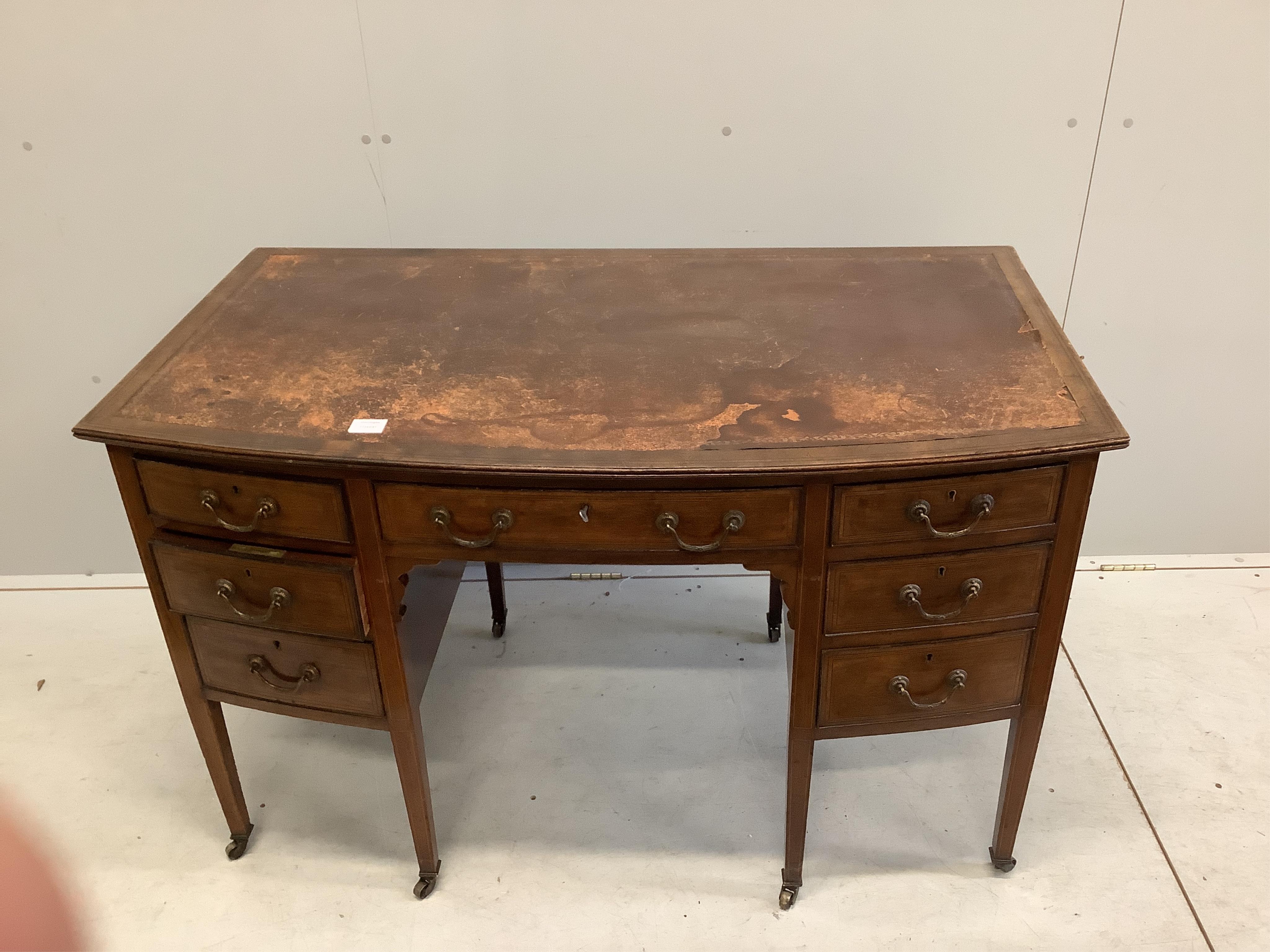 An Edwardian mahogany bowfront kneehole writing table, width 122cm, depth 70cm, height 76cm. Condition - fair